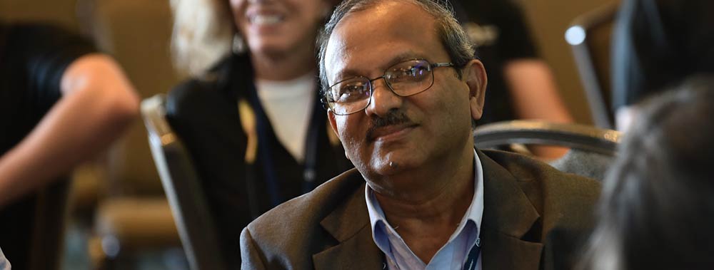 About-ISA-1.jpg Male conference attendee wearing glasses and brown blazer.
